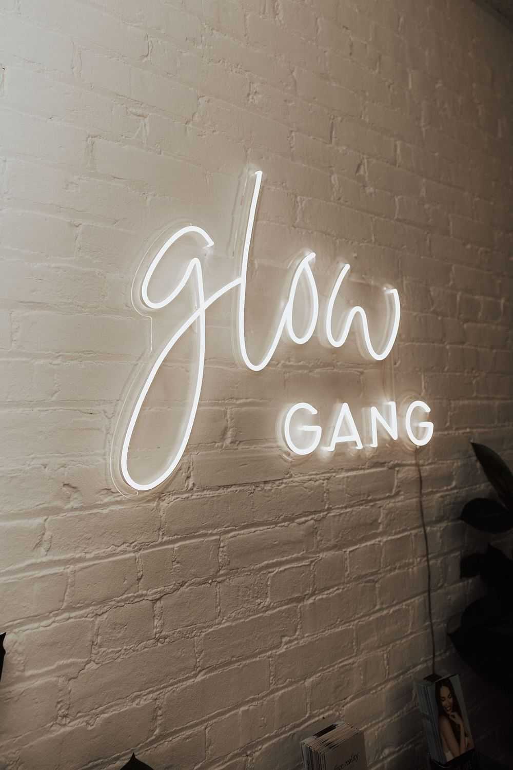 Neon sign on a brick wall reading 'Glow Gang'.